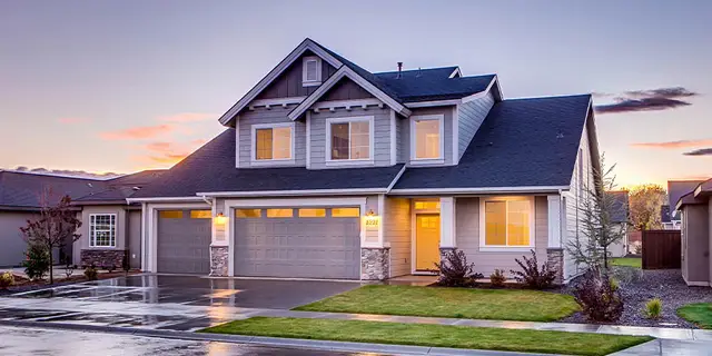 A two-story suburban home at dusk with a shared driveway and street frontage, the kind of residential parcel a utility or access easement typically burdens
